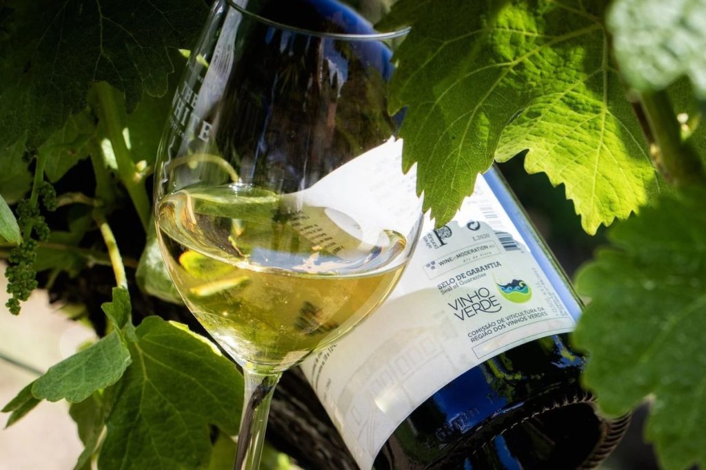 Garrafa de vinho verde com copo